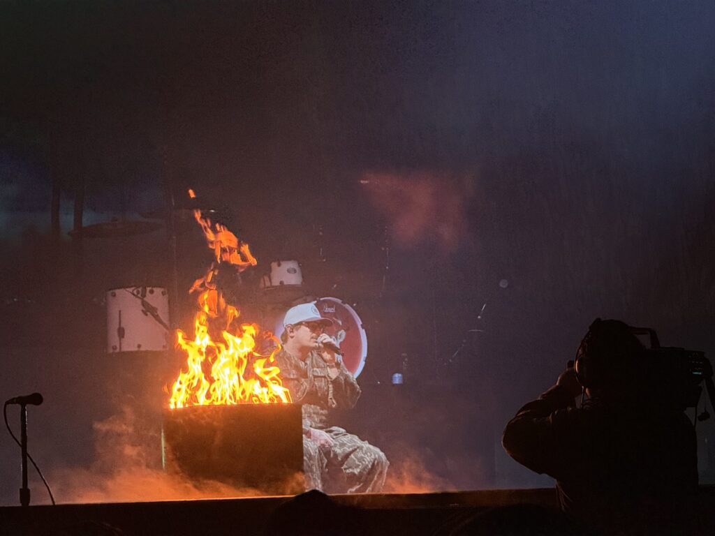 HARDY performs onstage beside a campfire set piece during his Omaha concert